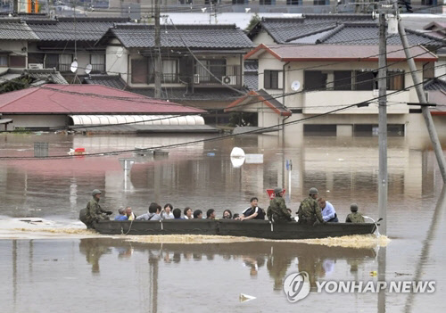 폭우로 물에 잠긴 일본 오카야마(岡山)현 구라시키(倉敷)시 마비초(眞備町) 마을에서 자위대원이 보트를 동원, 고립된 주민들을 구조하고 있다. <연합뉴스>